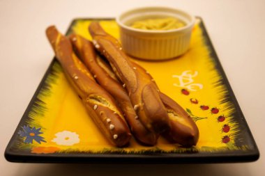 Grissini pretzels with mustard as an appetizer. clipart