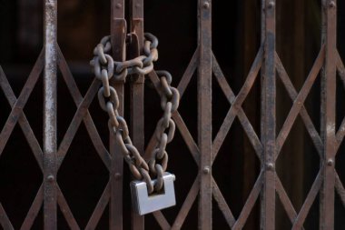 Asma kilit ve zincirli bir kapı.