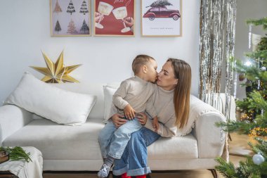 Bir anne ve küçük oğlu Noel 'i birlikte kutluyorlar. Güzel dekore edilmiş bir Noel ağacının yanındaki rahat bir halıda oturuyorlar. Şenlikli süslerle, peri ışıklarıyla ve hediyelerle. Sıcak ve...