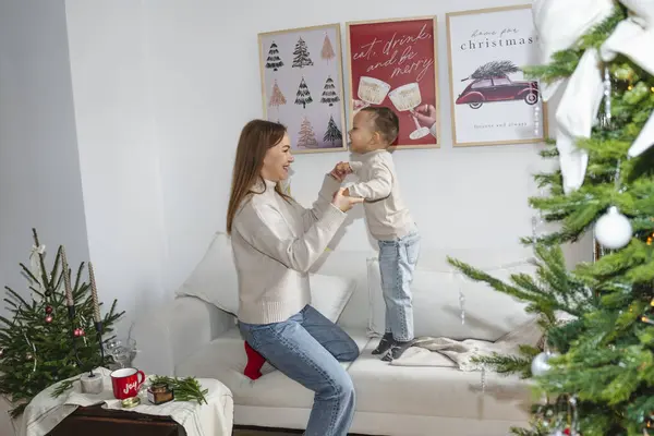 Bir anne ve küçük oğlu Noel 'i birlikte kutluyorlar. Güzel dekore edilmiş bir Noel ağacının yanındaki rahat bir halıda oturuyorlar. Şenlikli süslerle, peri ışıklarıyla ve hediyelerle. Sıcak ve...
