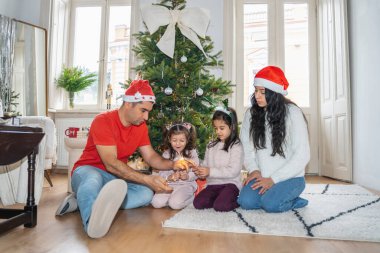 Children lighting sparklers near a festive Christmas tree. Happy moments of anticipation for Christmas and New Year, family warmth, and the magical holiday atmosphere. clipart