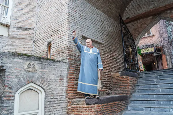 Bir çan çalıcı açık gökyüzünün altında büyük kilise çanlarını çalar. Geleneksel bir ayin dini bir ayinin başlangıcını simgeliyor..