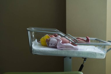 A touching moment of childbirth in a hospital. Doctors and staff assist the mother while the father shares in the joy of the newborn's first moments. clipart