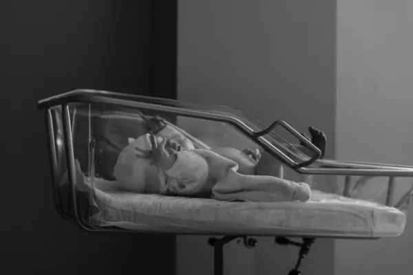 Hastanede dokunaklı bir doğum anı. Doktorlar ve çalışanlar anneye yardım ederken baba da yeni doğan bebeğin ilk anlarının mutluluğunu paylaşıyor..