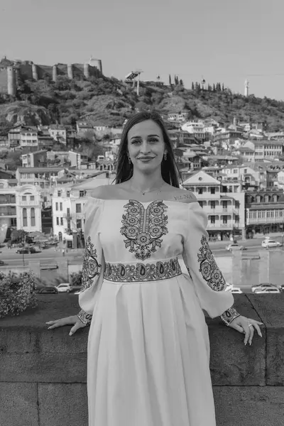 Damat geline evlilik teklifi ederken, bir nişan yüzüğü takıp nazikçe yanağından öpüyor. Çift geleneksel Ukrayna nakışlı düğün kıyafetleri giyer, Tbi 'nin manzaralı arka planına karşı sevgi ve bağlılığı kutlar.