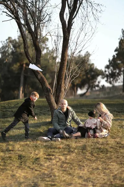 Dört kişilik neşeli bir aile, bir baba, bir anne, iki yaşında bir kız ve bir bahar parkında kağıt uçaklarla oynayan sekiz yaşında bir oğul. Koşar, güler ve doğanın tadını çıkarırlar. Çevrelerinde çiçek açan ağaçlar ve şehir manzaralı yeşil çimenler vardır..
