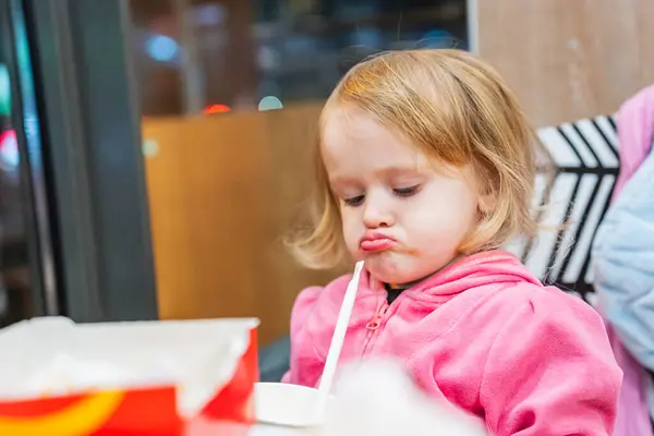 Komik küçük bir kız fast food yiyor, patates kızartması yiyor, hamburger yiyor ve meyve suyu içiyor. Onun şakacı asabiyeti sahneye ekstra bir mizah katıyor..