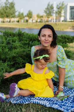 Neşeli genç bir anne ve sevimli kıvırcık saçlı küçük kızı doğada birlikte harika bir gün geçiriyorlar. Gülerler, koşarlar, yemyeşil bir parkta oynarlar, huzur içinde yürürler.