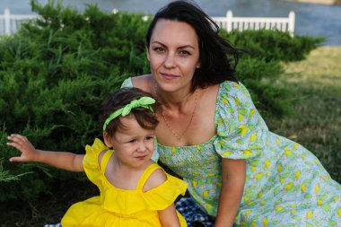 Neşeli genç bir anne ve sevimli kıvırcık saçlı küçük kızı doğada birlikte harika bir gün geçiriyorlar. Gülerler, koşarlar, yemyeşil bir parkta oynarlar, huzur içinde yürürler.