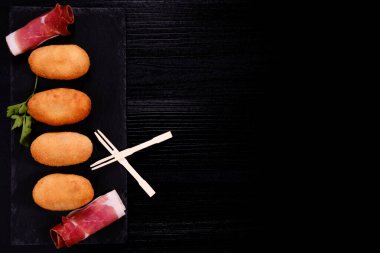 Jambonlu kroketler dikdörtgen levhada ve sağda negatif boşluk var.