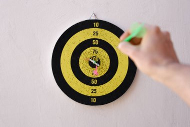 Sigara içmenin riskleri hakkında farkındalığı artırmak için dart okuna nişan alan bir elin birinci şahıs görüşü. Sigara hedefin tam ortasında iki ok tarafından delinmiş..