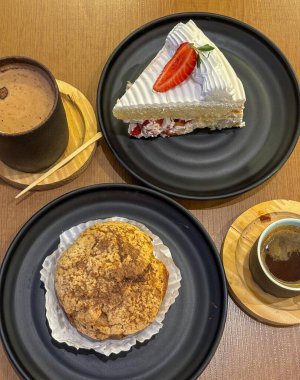 Japon fırınında ikindi kahvesi, kek, krema, kapuçino ve kahve.