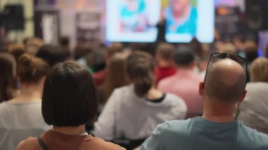 Genç profesyonellerin seyircileri teknolojik yenilik sunumunu gözlemliyor