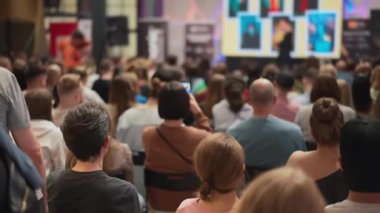 Genç profesyonellerin seyircileri teknolojik yenilik sunumunu gözlemliyor