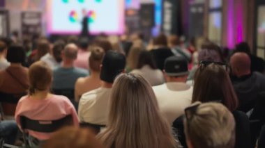 Genç profesyonellerin seyircileri teknolojik yenilik sunumunu gözlemliyor