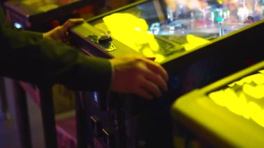 Adam, neon ışıklı Asya kafede atari oyununda pinball oynayarak çocukluğunu yeniden yaşıyor.