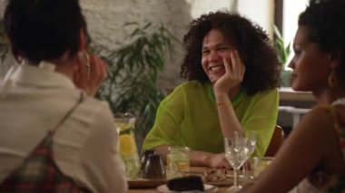 4k homoseksüel arkadaşlar barda masada konuşur ve içerler. Güzel lezbiyen kadınlar, eşcinsel bir adam konuşuyor ve gülümsüyor, doğum gününü kutluyor ve masada oturuyor. Genç çok ırklı insanlar alkol içiyor
