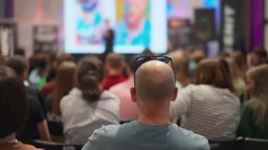 Genç profesyonellerin seyircileri teknolojik yenilik sunumunu gözlemliyor