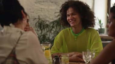 4K Güzel Igbt arkadaşları barda oturup kokteyl içerler. Lezbiyen kadınlar, gülümseyen ve bakan bir adam, içecek içen ve masada oturan. Farklı homoseksüel gruplar