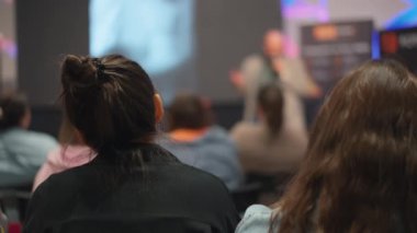 Genç profesyonellerin seyircileri teknolojik yenilik sunumunu gözlemliyor
