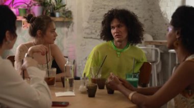 4K genç eşcinsel arkadaşlar içecek içer ve barda sohbet ederler. Güzel lezbiyen kadınları yakından görmek, geylerin sohbet edip gülümsemesi, kokteyl içmesi ve masada oturması. Çok ırklı grup