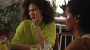 4K Lgbt insanları kokteyl içer ve barda birlikte iyi vakit geçirirler. Gülümseyerek gülen, içecek içen ve kafede masa başında oturan güzel eşcinsel lezbiyenlerin yakın çekimi. Grup