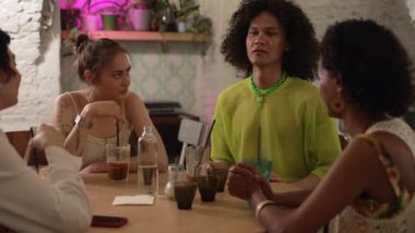 4K Lgbt çalışanları barda konuşuyor ve içiyor. Güzel kadınlar, kutlayan ve gülümseyen bir adam, kafede içki içen bir adam. Bir grup çok ırklı eşcinsel arkadaş sohbeti.