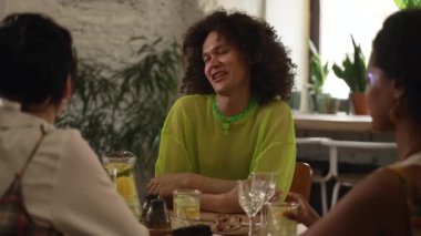 4K Güzel Igbt insanları bardaki masada eğlenir ve içki içerler. Kadınlar gülümseyerek konuşuyor, alkol kokteyli içiyor, doğum gününü kutluyor ve kafede masa başında oturuyorlar. Çoklu Etnik