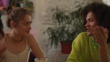 4K homoseksüel insanlar konuşuyor ve barda masaya oturuyorlar. Genç ve güzel kadınları yakından görmek, gay erkeklerin konuşup gülmesi, kutlama yapması ve masasında oturup içkileri yudumlaması. İkili olmayan lgbt