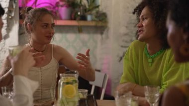 4K Lgbt insanları içki içer ve barda masada konuşurlar. Güzel kadınlar, erkekler kokteyl içiyor ve gülücüklerle konuşuyor, iç kısımdaki masada oturuyorlar. Homoseksüel genç dostların iyi ilişkileri vardır.