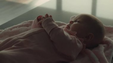 Battaniyenin üzerinde banyo zamanını bekleyen bir bebek erken su deneyimlerine yardımcı olur. Dikkatli hazırlanmış bir ortam duyusal gelişimi teşvik eder. Erken bebek gelişimi kavramı