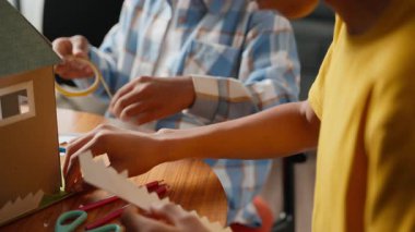 Güneş enerjisi modeli için çit inşa eden, okul bilim projesi için ödev yapan, ekip çalışması yapan ve yenilenebilir enerji eğitimi alan kardeşlerin yakın çekimi. Yüksek kalite 4k görüntü