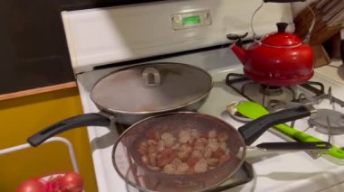 Mutfakta fırında ev yapımı sotelenmiş patates ve İtalyan sosisi pişirmek.