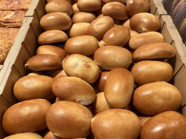 Fırın vitrinindeki ahşap tepside çörekler.