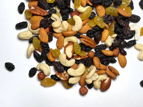 Karışık fındık, badem, ceviz, kaju, fındık, kuru erik ve kuru üzüm. Farklı fındık karışımı. Beyaz arka planda çeşitli fındıklar ve kurutulmuş meyveler.