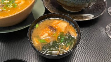 Buharı tüten bir kase miso çorbasının yakın çekimi, bir Japon mutfağı. Geleneksel bir siyah lacquer kasesinde servis edildi. Sağlıklı beslenme ve Japon mutfağı geleneklerini göstermek için mükemmel.