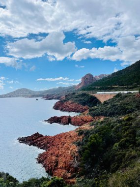 Fransa 'nın güneyinde, Saint Raphael, Fransa' da gün batımından önce, deniz ve dağlara bakan Kızıl Dağ 'ın altından geçen tren..   