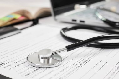 Not defteri arkaplan ve dizüstü bilgisayarında Yetişkin Yeni Hasta Anketi bulunan telefon ya da stetoskop