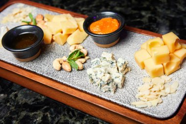 Tahtaya fındık ve bal konmuş peynir tabağı. Yakın çekim, seçici odaklanma