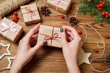 Kız elinde Noel aksesuarlarının arka planında bir hediye kutusu tutuyor.