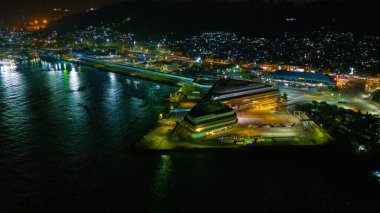 Parıldayan ışıkların suya yansıdığı canlı bir sahil manzarasının gece görüşü. Yüksek kalite fotoğraf