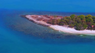 Pulau Merak Kecil 'in temiz suları ve Endonezya' nın Merak Limanı yakınlarındaki sahil boyunca küçük insan gruplarıyla birlikte kıyılarını gösteren bir hava görüntüsü.
