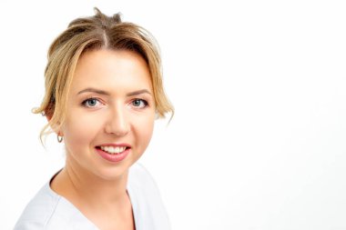 Close-up portrait of young smiling female caucasian healthcare worker standing staring at the camera on white background