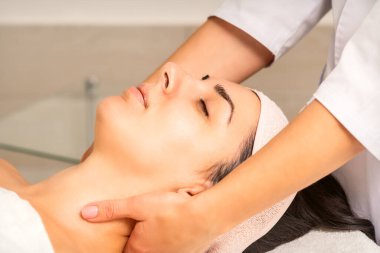 Yüz masajı. Beyaz bir kadın güzellik kliniğinde boynuna masaj yaptırıyor.