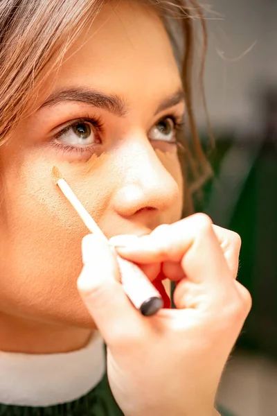 Smuk Ung Brunette Kvinde Der Modtager Makeup Med Stick Concealer - Stock-foto