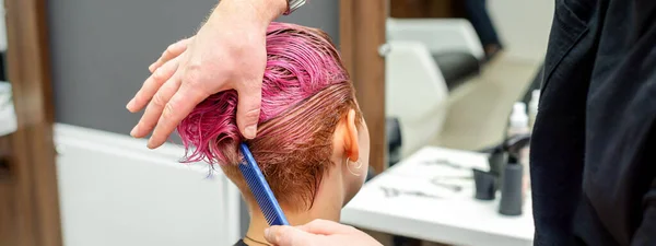 理发店里 一位美发师正在梳理美发师沙龙里一位女性顾客染成的粉色湿透了的短发 — 图库照片