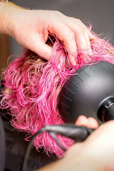 若い白人女性の短いピンクのボブの髪型を乾燥させます黒髪のドライヤーとヘアサロンで男性の美容師の手でブラシ 閉じる — ストック写真