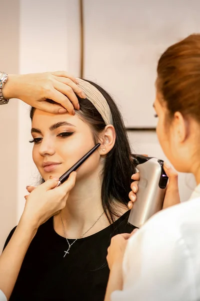 Maquillaje Artista Usando Aerógrafo Cara Una Joven Mujer Caucásica Salón — Foto de Stock