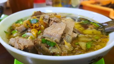 Sade soslu et çorbası. Tipik Boyolali, Central Java. Kahvaltı, öğle yemeği ya da akşam yemeği için uygun. Endonezya 'da popüler bir yemek olan Soto Seger, üstü kızarmış sarımsak ve kereviz yapraklarıyla kaplı, ahşap bir masada küçük bir kasede servis edilir.