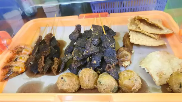 stock image Various side dishes such as fried potato balls (perkedel), fried tempeh, fried shrimp, lung satay and tripe satay. An additional menu usually served together with Soto Seger typical of Boyolali, Central Java